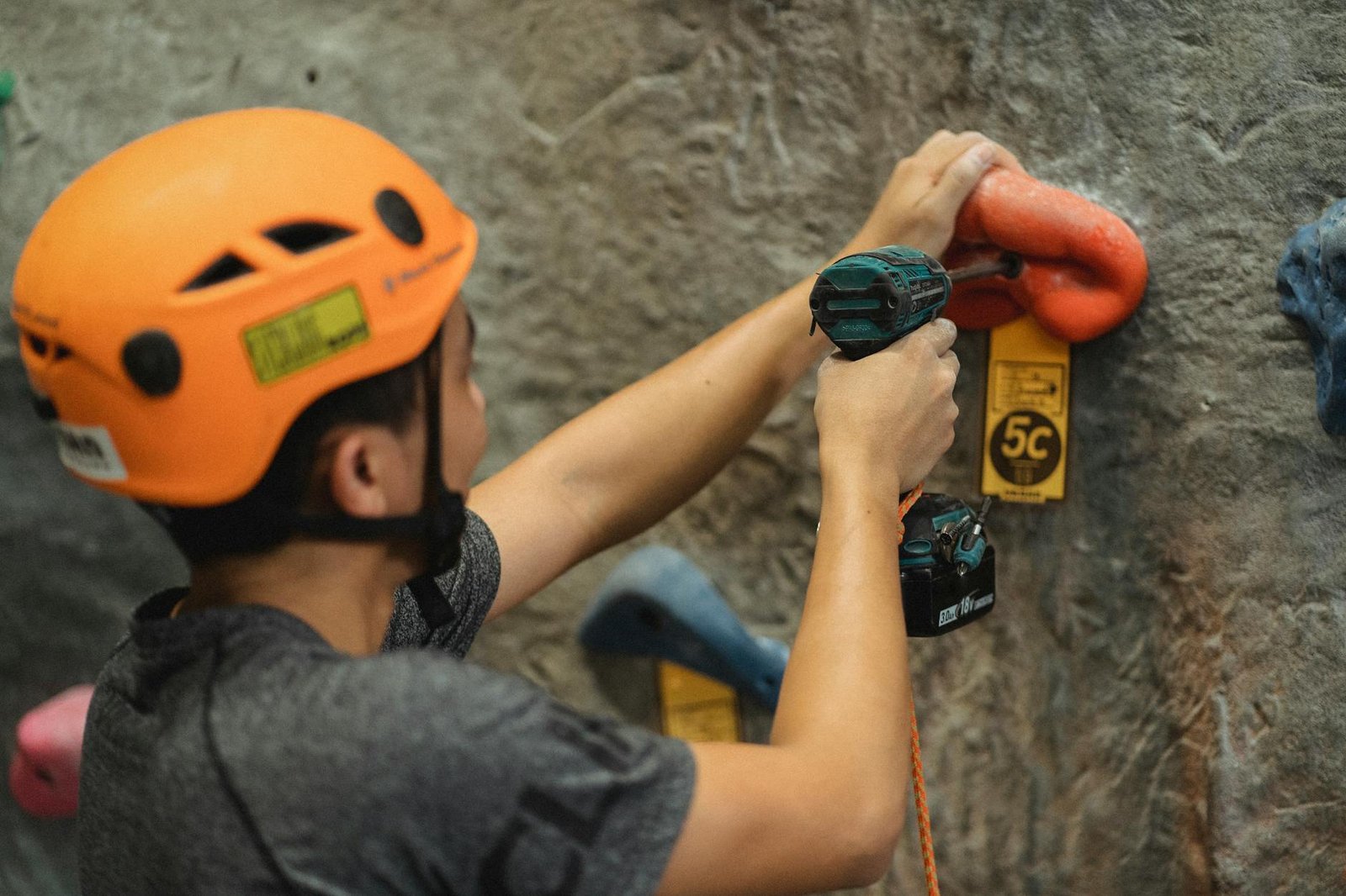 https://www.pexels.com/photo/crop-athlete-fasten-climbing-hold-with-screwdriver-on-wall-in-gym-5383795/