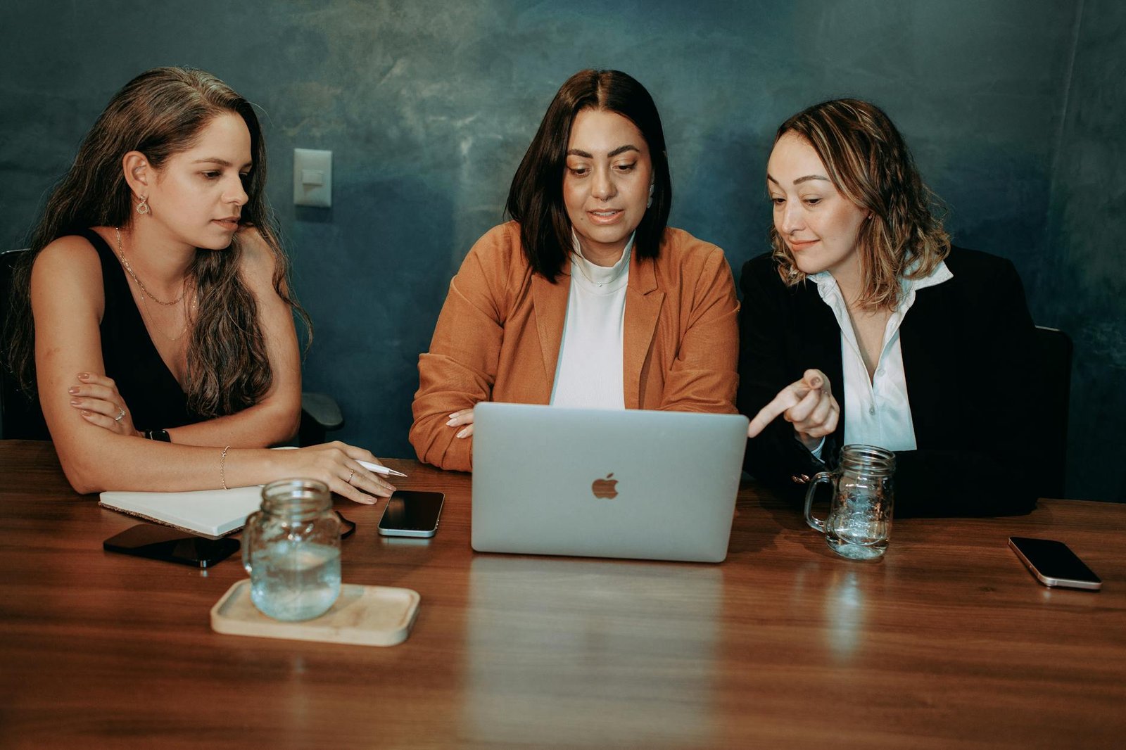 https://www.pexels.com/photo/women-at-a-meating-using-laptop-at-a-wooden-table-27086177/