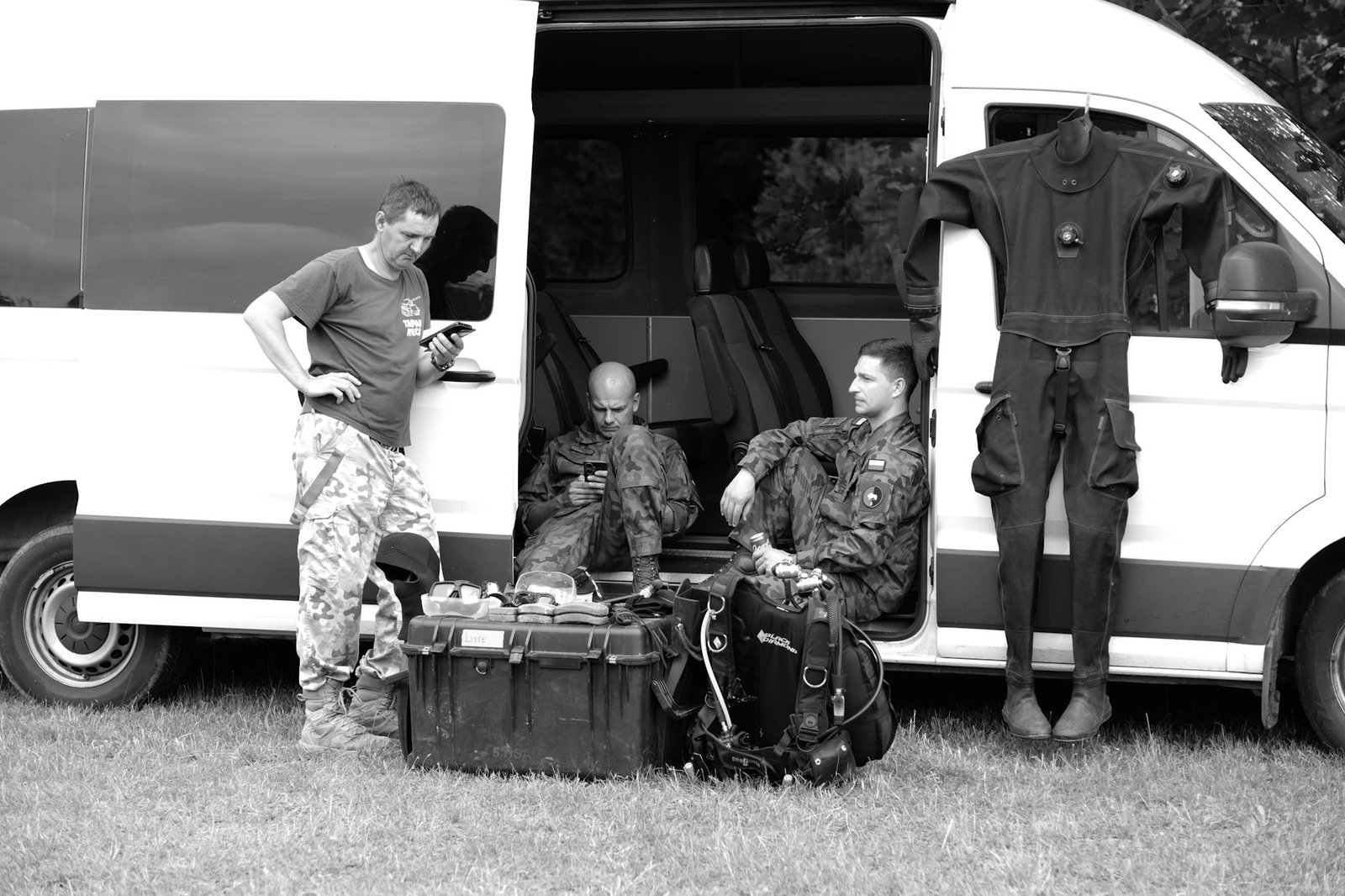 https://www.pexels.com/photo/a-group-of-people-sitting-in-front-of-a-van-27970286/