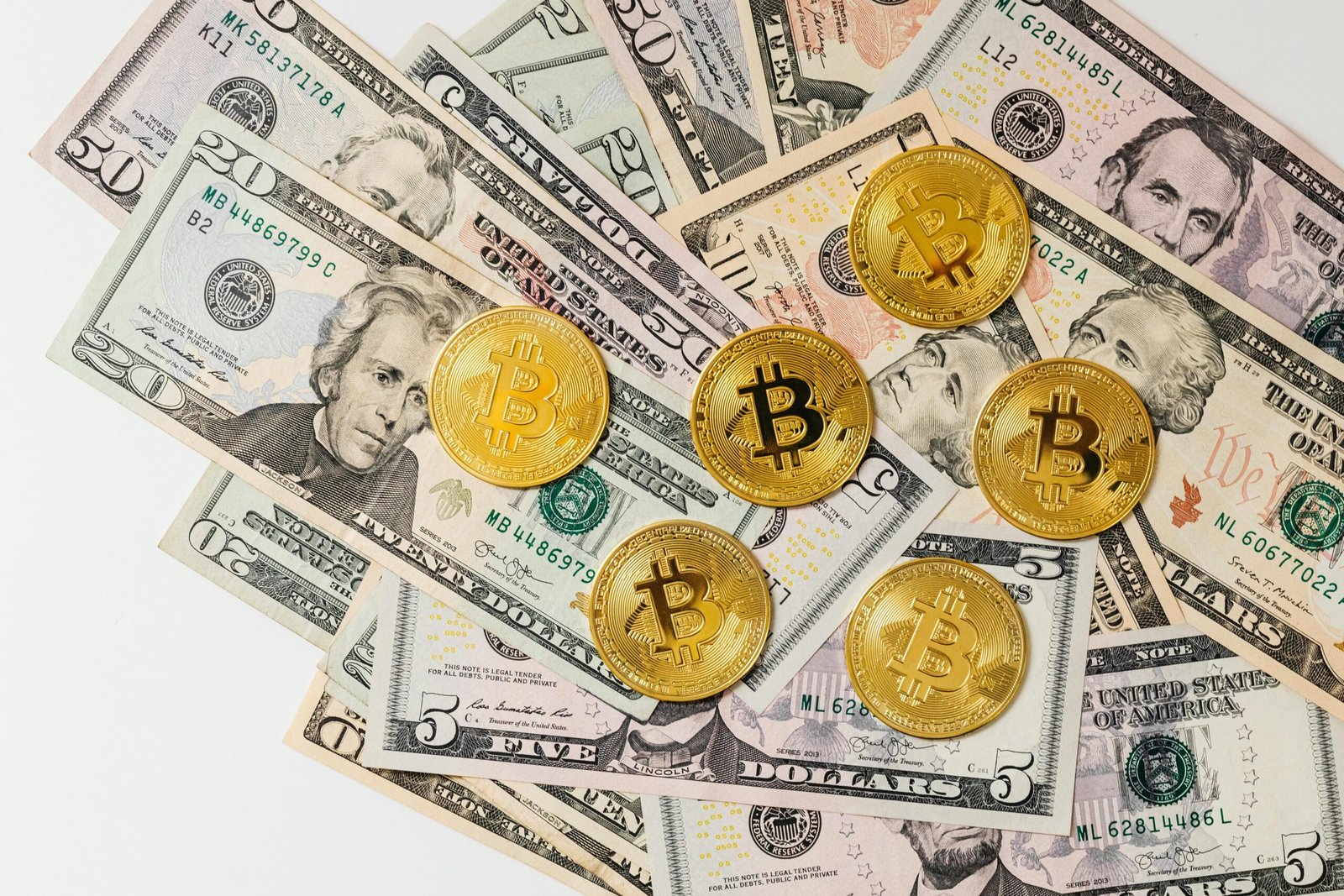 Gold Bitcoins on top of scattered US dollar bills